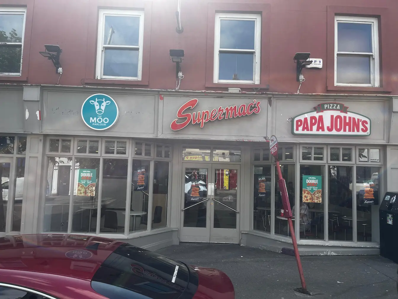 Supermac's and Papa John's restaurant exterior in Ballyhaunis, Ireland. Features a shared entrance, red 