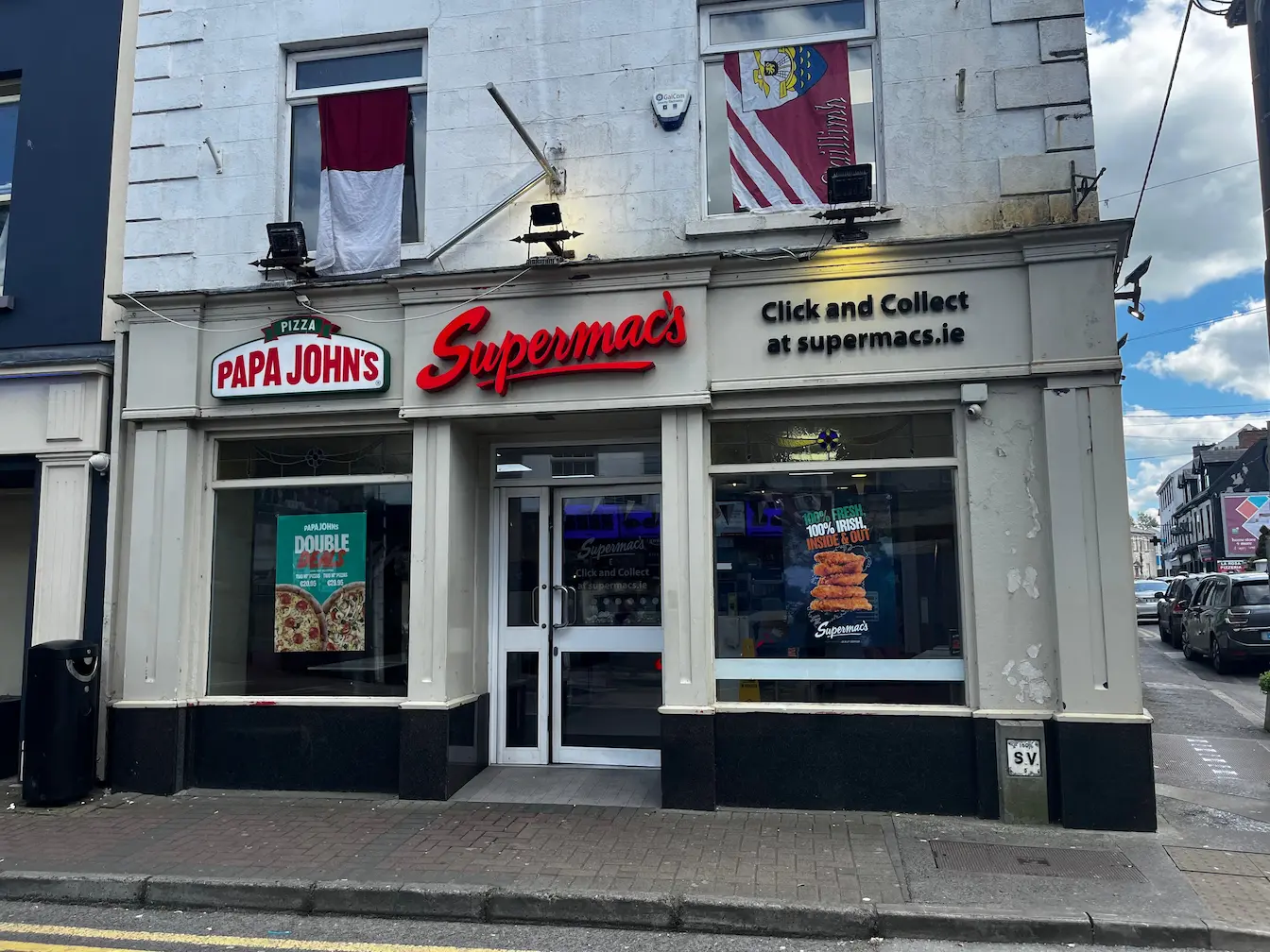 Storefront image of Supermac's Tuam Town with Papa John's and Supermac's signage clearly visible